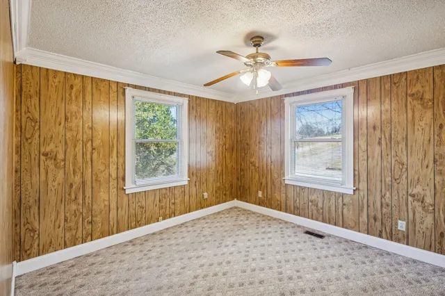 a view of an empty room and window and chandelier fan