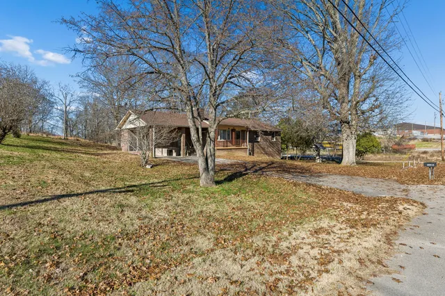 a front view of a building with large trees