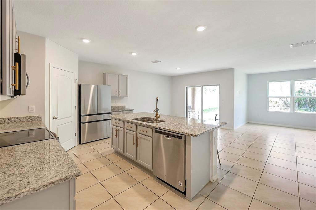 2726 Harmonia Hammock Road Harmony, FL 34773 - Photo 4 of 18 a kitchen with stainless steel appliances granite countertop a refrigerator and a sink