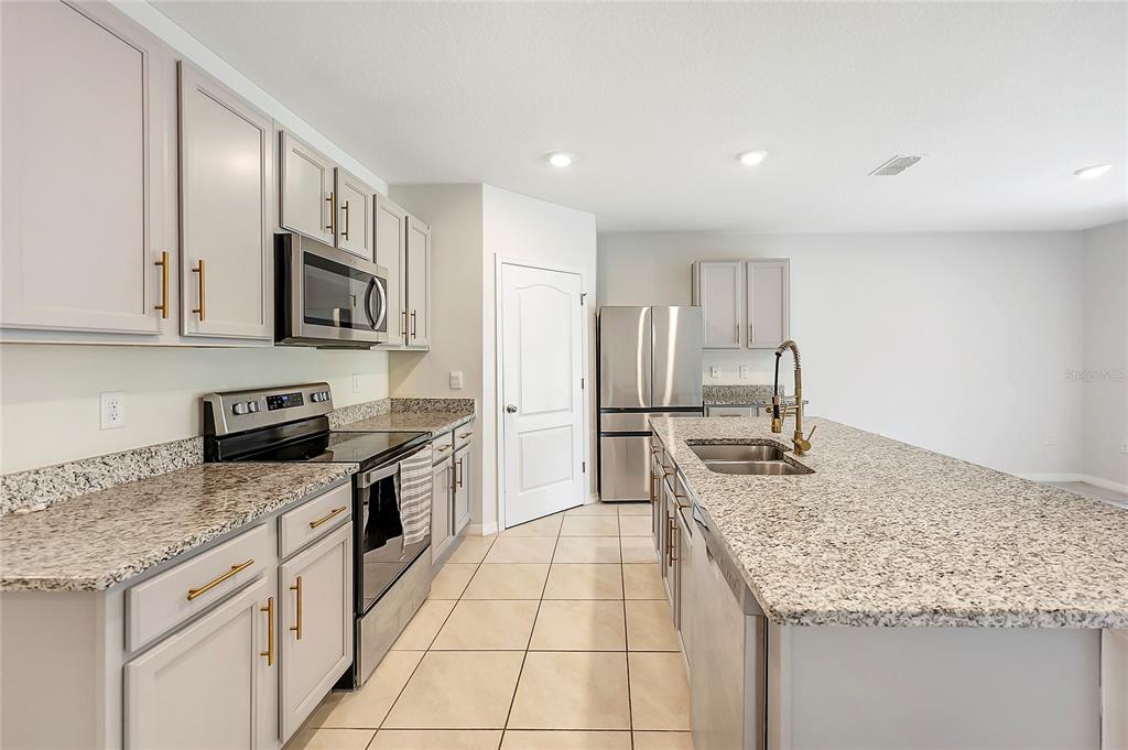 2726 Harmonia Hammock Road Harmony, FL 34773 - Photo 6 of 18 a kitchen with stainless steel appliances granite countertop a sink stove and cabinets