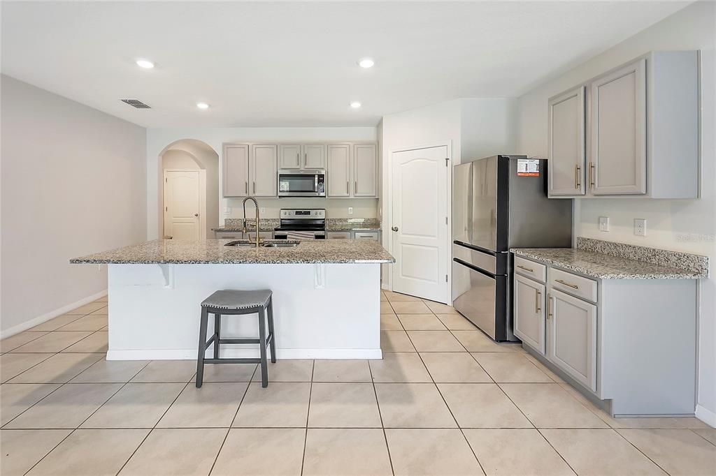 2726 Harmonia Hammock Road Harmony, FL 34773 - Photo 8 of 18 a kitchen with stainless steel appliances granite countertop a stove a sink a microwave and a refrigerator