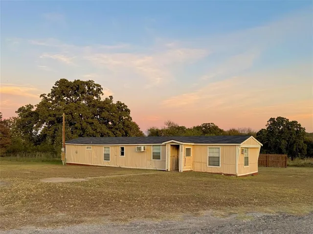 a front view of house with yard and trees