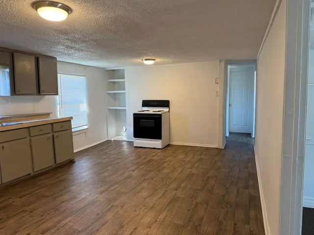 a view of a kitchen with wooden floor and electronic appliances