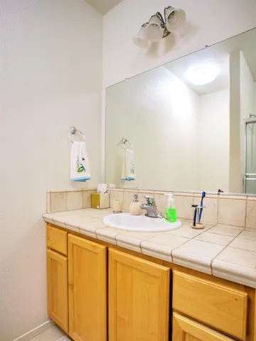 a bathroom with a granite countertop sink and a mirror