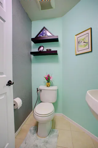 a white toilet sitting next to a bathroom sink and vanity