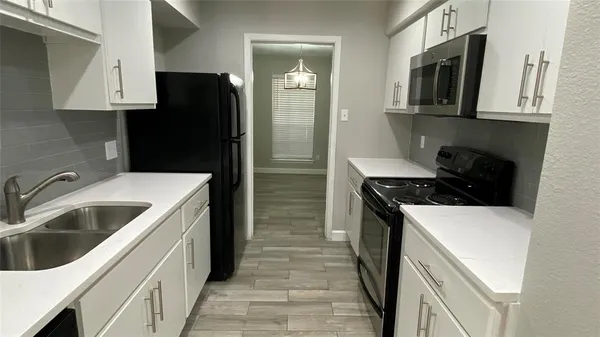 a kitchen that has a sink and a stove top oven
