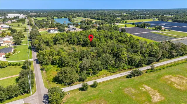 an aerial view of residential houses with outdoor space and trees