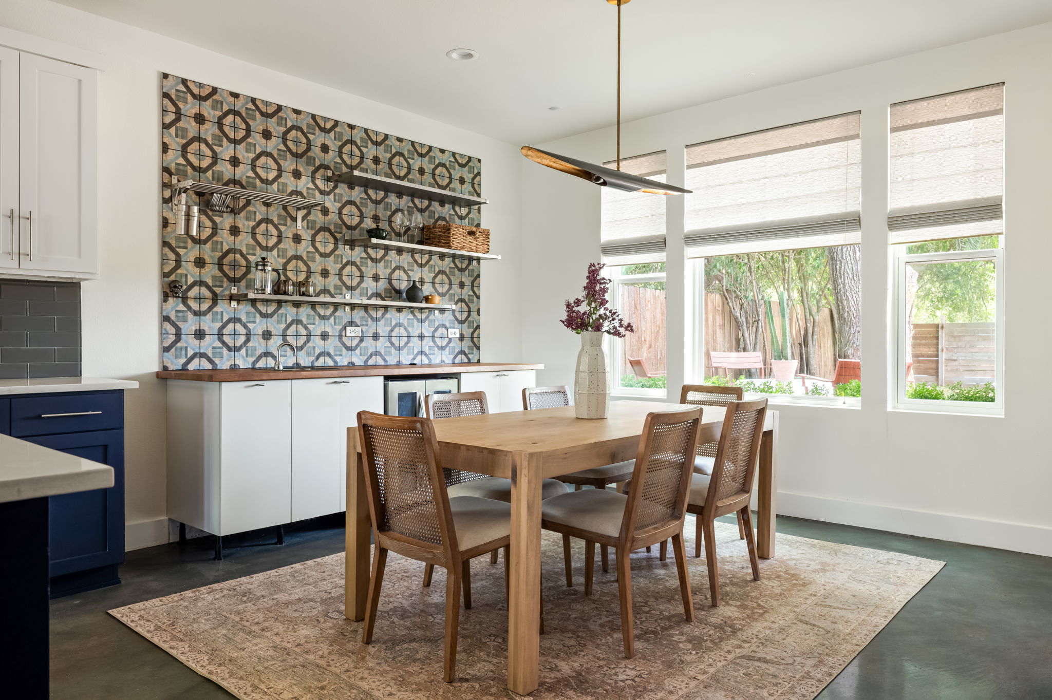 1902 Webberville Road, Unit B Austin, TX 78721 - Photo 12 of 39 Natural light floods this dining area, featuring a decorative tiled wall and sleek built-in cabinetry.