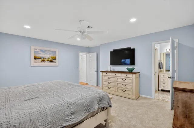 a bedroom with a bed and a flat screen tv in white walls