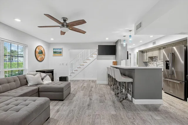 a living room with stainless steel appliances furniture and a window