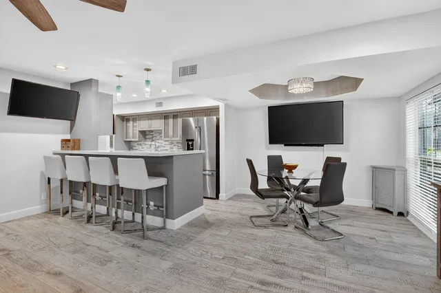 a view of a dining room with furniture and a flat screen tv