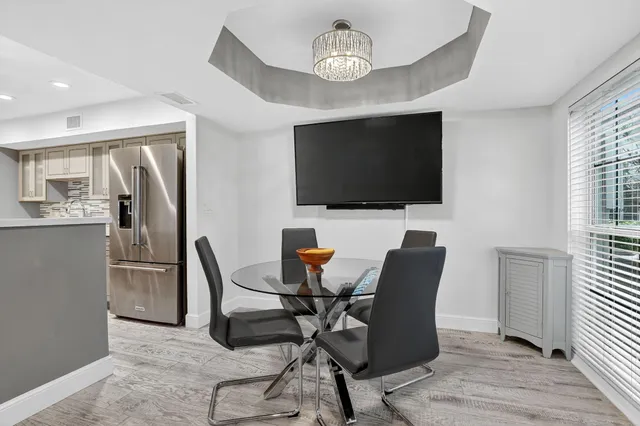 a view of a livingroom with furniture a flat screen tv and wooden floor