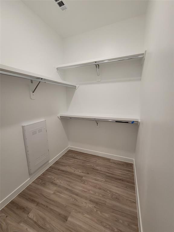 4801 Springdale Road, Unit 2211 Austin, TX 78723 - Photo 10 of 19 Ample shelving and hanging space in this well-appointed closet, featuring durable laminate flooring.