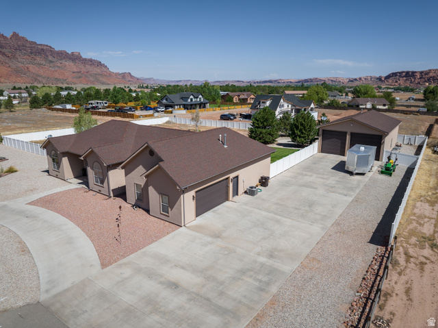 4635 East Sunny Acres Lane Moab, UT 84532 - Photo 1 of 56 Stucco exterior residence featuring an attached garage and a detached multi-bay garage