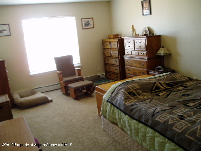 402 Evergreen Drive Rifle, CO 81650 - Photo 9 of 13 a bedroom with a bed and a chair