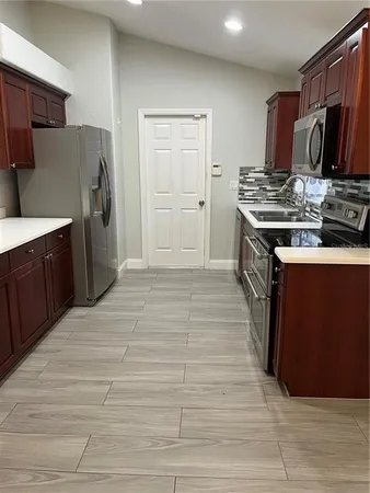 a kitchen with a refrigerator stove and wooden cabinets