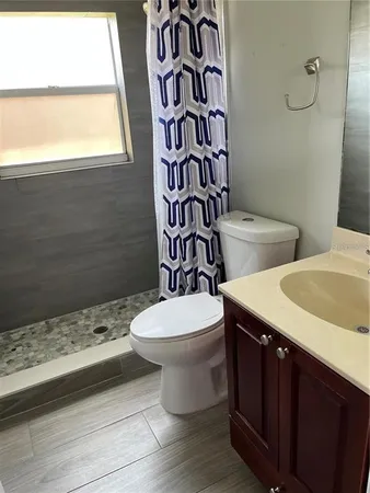 a bathroom with a toilet a sink and a window