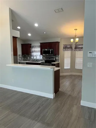 a kitchen with stainless steel appliances granite countertop a stove top oven a sink and a microwave