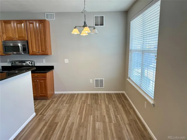 a view of a kitchen with wooden floor and electronic appliances