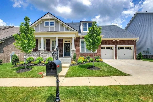a front view of a house with a yard and potted plants