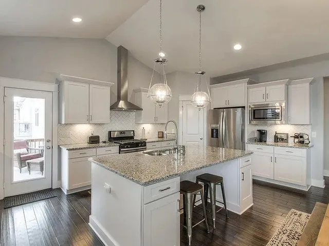 a kitchen with stainless steel appliances granite countertop a stove refrigerator and cabinets