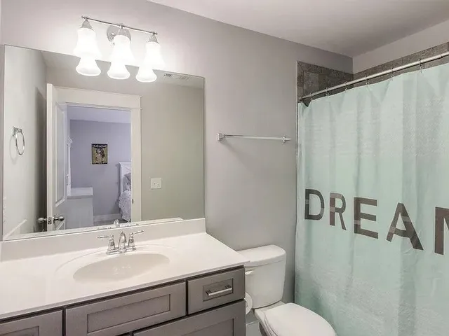 a bathroom with a sink vanity mirror and toilet