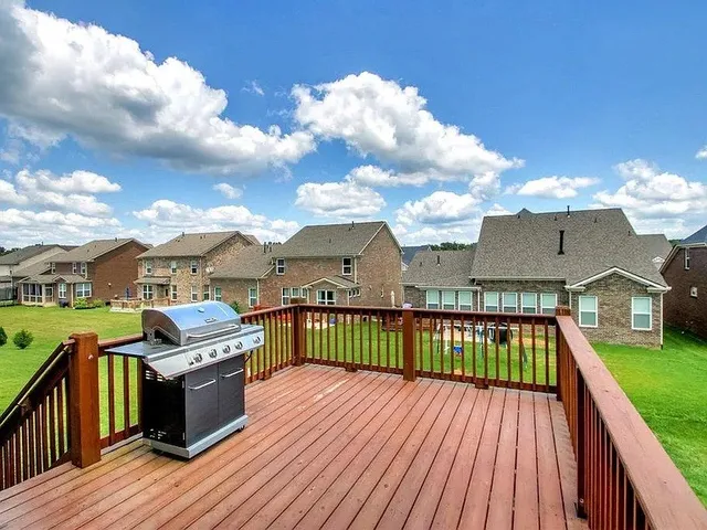 a view of a roof deck with couches chairs and wooden floor
