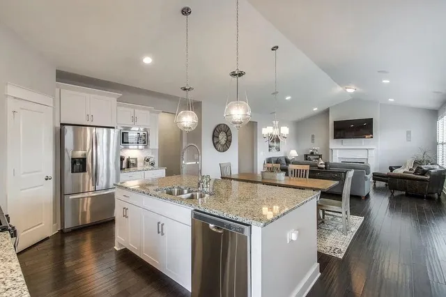 a large kitchen with kitchen island a large counter space stainless steel appliances and cabinets