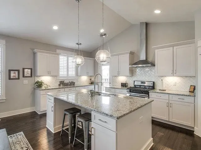a kitchen with stainless steel appliances granite countertop a sink stove and cabinets