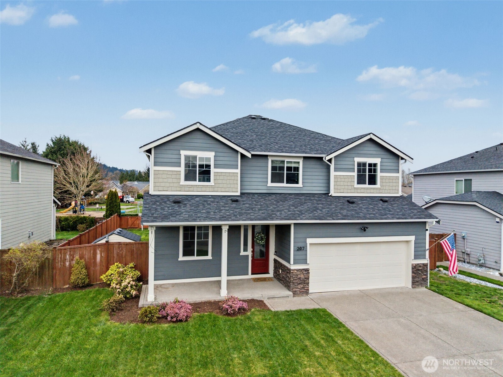 207 Fielding Street Northeast Orting, WA 98360 - Photo 32 of 37 a front view of a house with a yard and garage