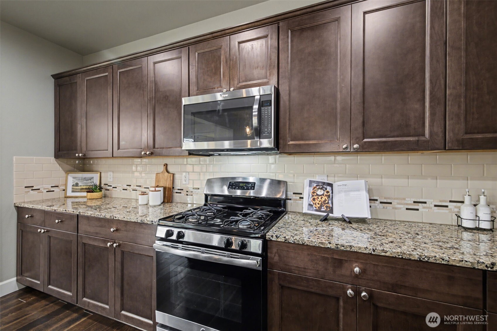 207 Fielding Street Northeast Orting, WA 98360 - Photo 10 of 37 a kitchen with granite countertop wooden cabinets and stainless steel appliances