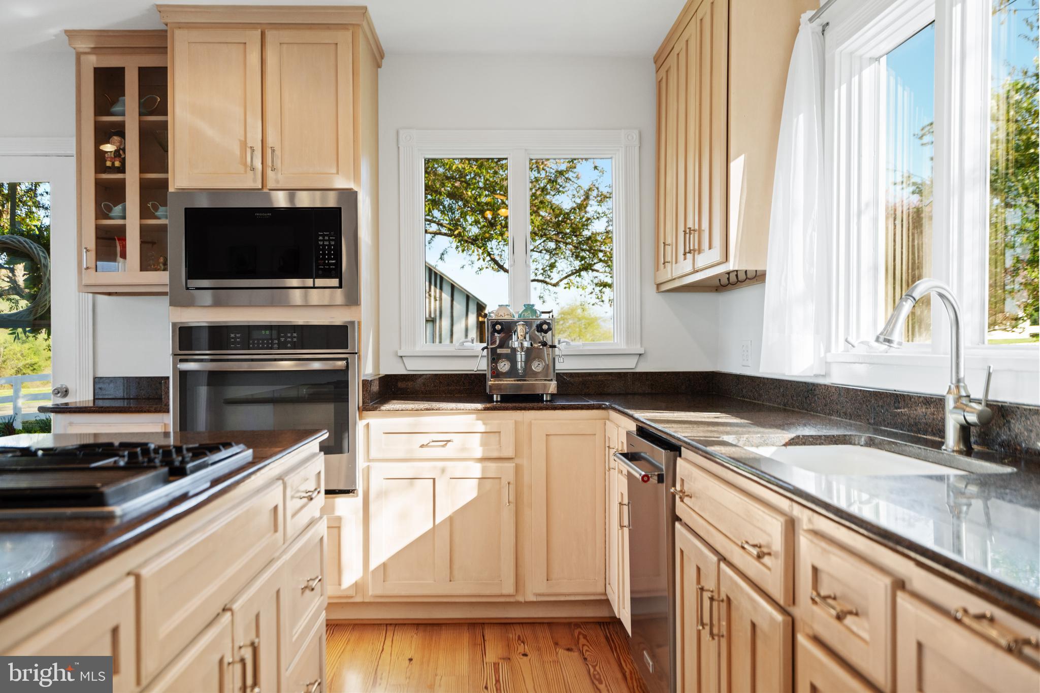 873 Hawlin Road Woodville, VA 22749 - Photo 21 of 45 a kitchen with stainless steel appliances granite countertop a stove a sink and a microwave