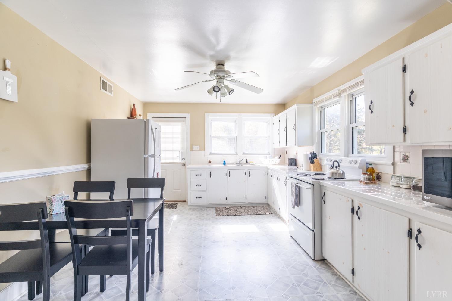 3676 Depot Road Rustburg, VA 24588 - Photo 7 of 37 a kitchen with white cabinets and wooden floor