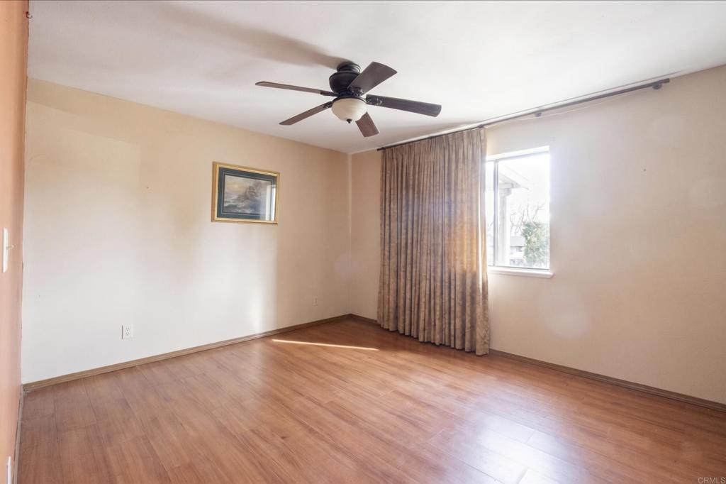 823 Rice Canyon Road Fallbrook, CA 92028 - Photo 14 of 30 an empty room with wooden floor chandelier fan and windows