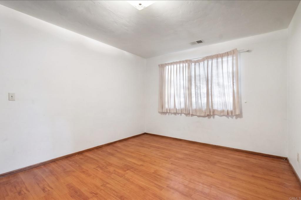 823 Rice Canyon Road Fallbrook, CA 92028 - Photo 16 of 30 an empty room with wooden floor and windows