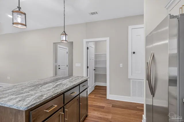 a bathroom with a granite countertop sink and refrigerator