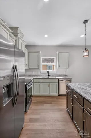 a kitchen with stainless steel appliances granite countertop a sink a stove and a refrigerator