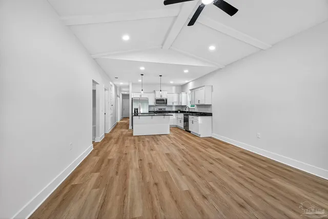 a kitchen with stainless steel appliances a refrigerator a stove top oven and white cabinets