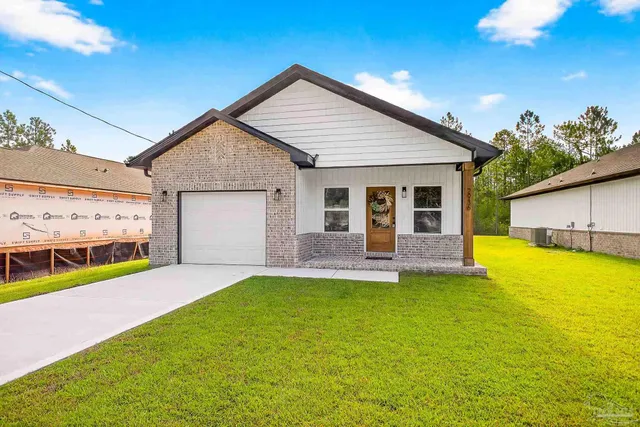 a view of a house with a yard and a garage
