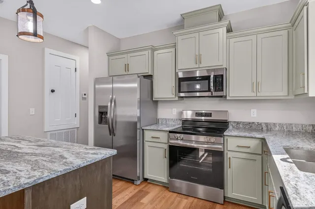 a kitchen with stainless steel appliances granite countertop a stove microwave refrigerator and sink