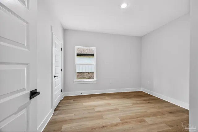 a view of a room with wooden floor and a ceiling fan