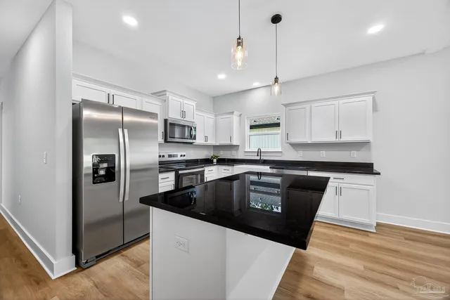 a kitchen with granite countertop a refrigerator and a sink