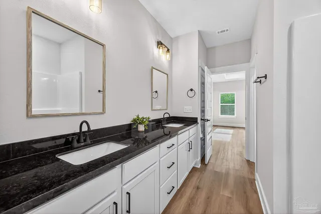 a spacious bathroom with double sink and a mirror