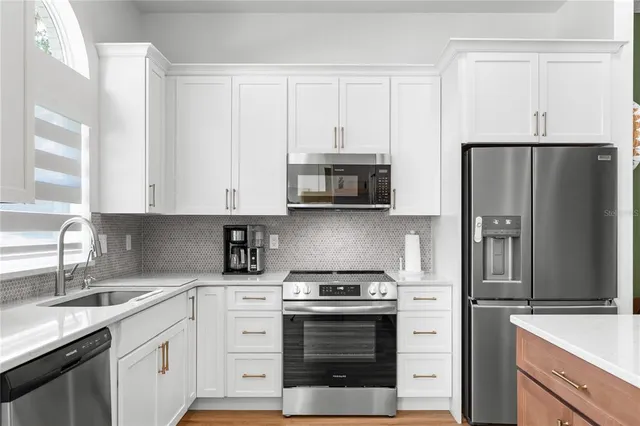 a kitchen with stainless steel appliances white cabinets and a sink