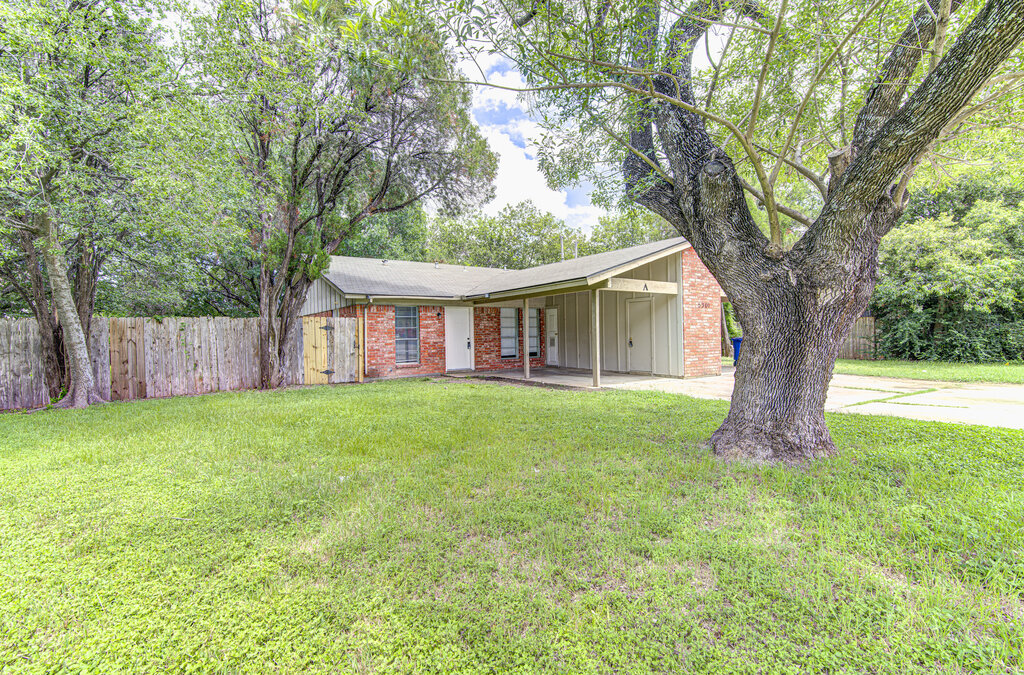 5301 Indio Circle, Unit A Austin, TX 78745 - Photo 2 of 25 A classic brick exterior home with a welcoming front yard, shaded by mature trees and a sturdy fence.