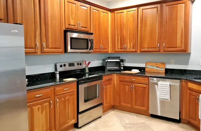 a kitchen with stainless steel appliances granite countertop a stove a sink and dishwasher