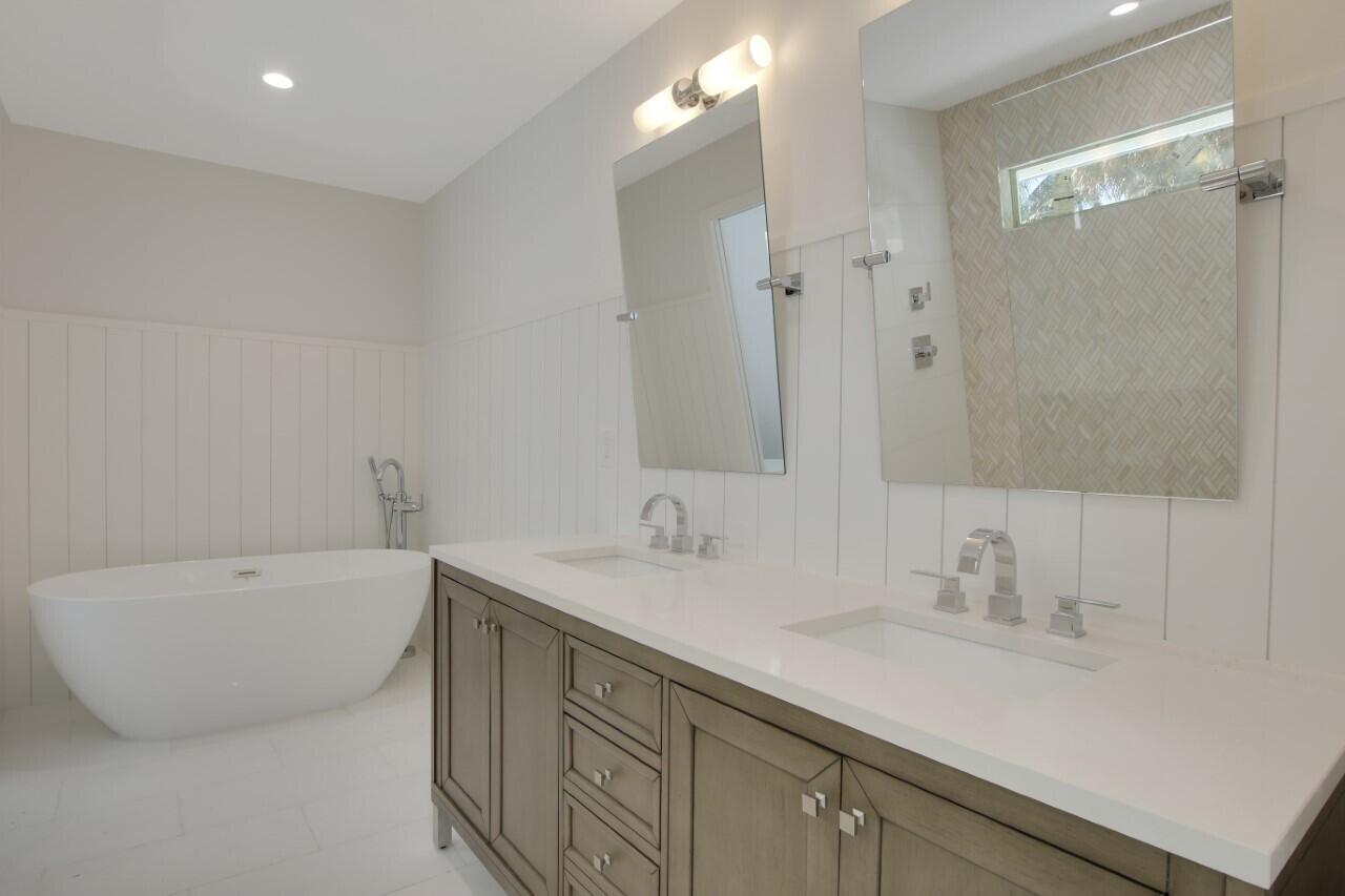 1504 Ocean Way Jupiter, FL 33477 - Photo 12 of 17 a bathroom with a sink double vanity granite tub shower and a mirror