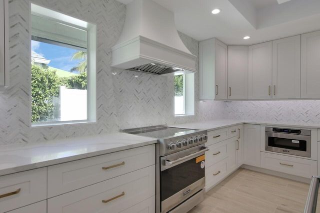 a kitchen with granite countertop cabinets stainless steel appliances and a window
