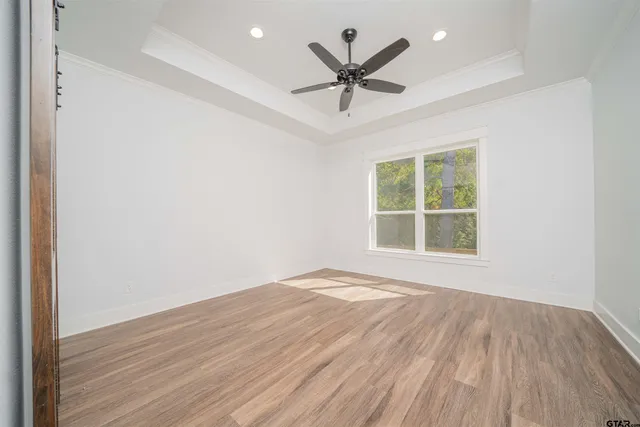 an empty room with a window and a ceiling fan