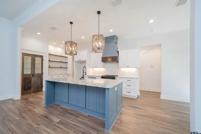 a kitchen with a sink stove and wooden floor